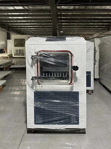 Right side angled view of a white vacuum freeze dryer machine wrapped in plastic film inside a warehouse facility.